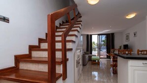Ein modernes Interieur mit einer Holztreppe, einer Küchenzeile und einem Essbereich.
