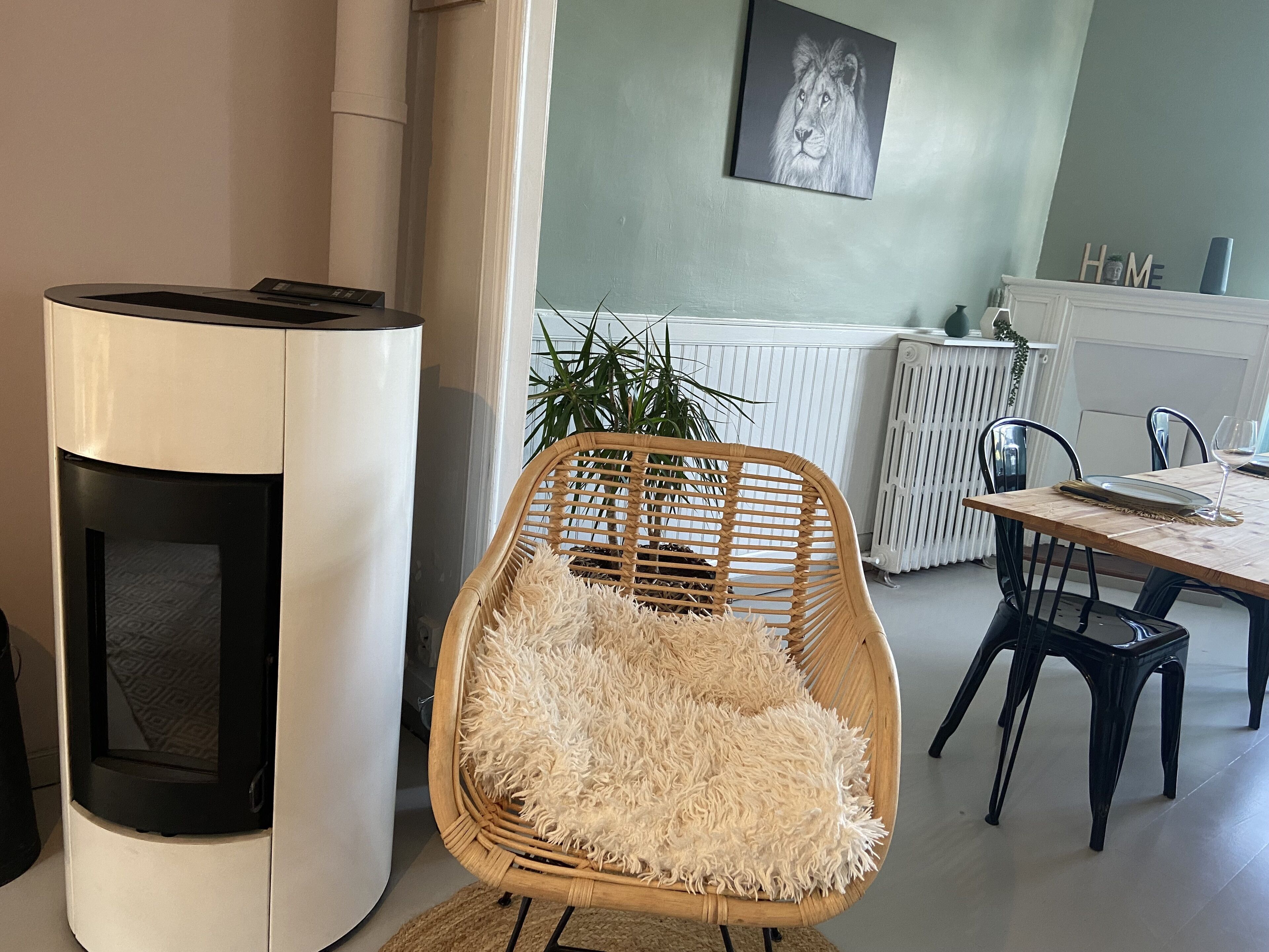 A modern kitchen with a built-in stove, a dining area with a wooden table and chairs, and a wall-mounted artwork.