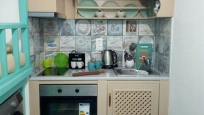 Une cuisine équipée d’une machine à café, d’une bouilloire et d’une boîte d’épices pour assaisonner la viande.