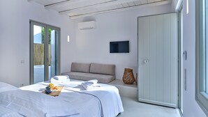 Un dormitorio moderno con cama, sofá, televisor y armario.