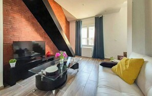 Relax in this stylish living room with a brick accent wall, flat-screen TV, and comfortable sofa.