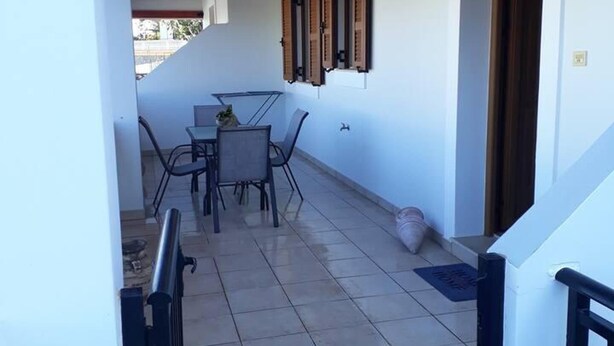 A covered outdoor area with a tiled floor, a table with chairs, and a wooden ceiling. - Apartment - Sleeps 5 - Parking - Private Terrace (Kalymnos)