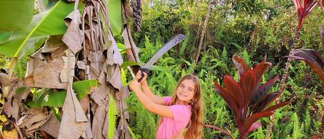 A person climbing a tree with a large knife.