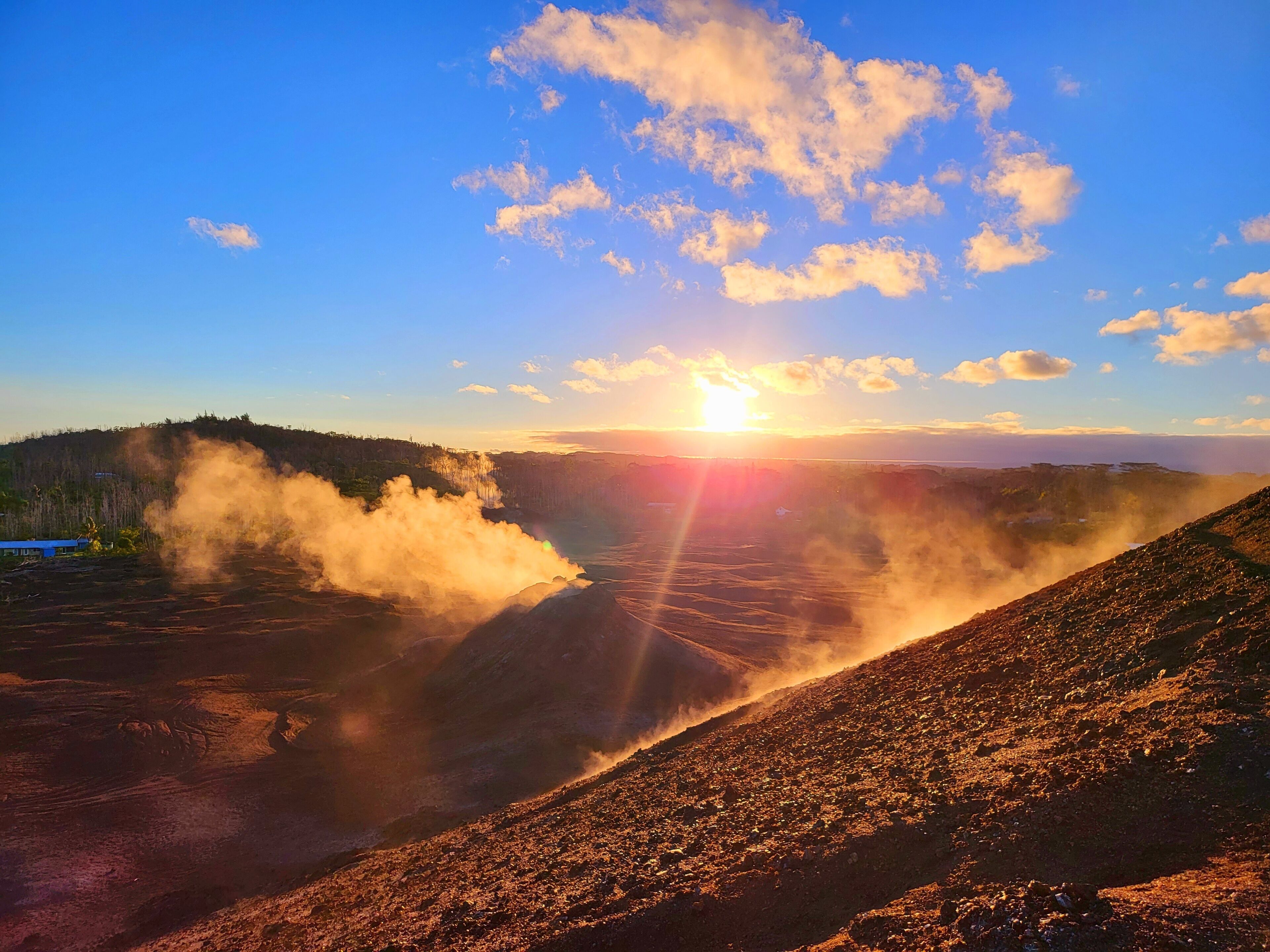 A volcanic landscape with a clear sky and a sunset.