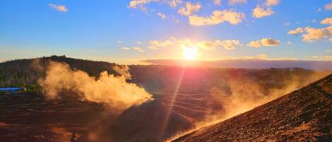 A volcanic landscape with a clear sky and a sunset.