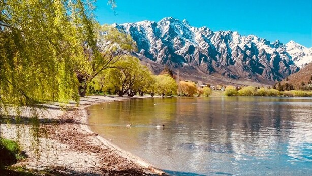 Une vue paisible sur un lac, avec une chaîne de montagnes en arrière-plan.