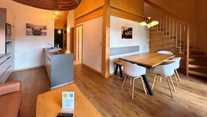 A modern interior with a wooden dining area, a reception desk, and a staircase. - Superior Apartment # 2 for up to 6 persons with IR Sauna (St. Georgen am Kreischberg)