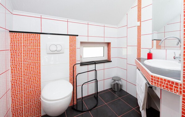 A bathroom with a toilet, sink, and mirror. - Awesome home in Velika with heated swimming pool (Velika)