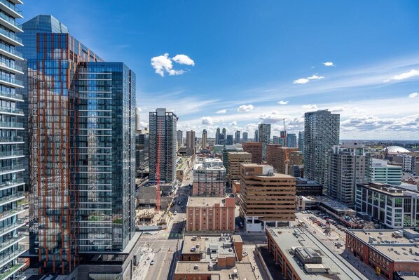 A cityscape with modern high-rise buildings, a mix of commercial and residential structures, and a clear blue sky.