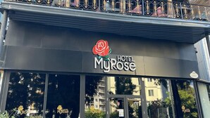 A hotel with a balcony, outdoor seating, and a rose logo. - Hotel MyRose (Batumi)