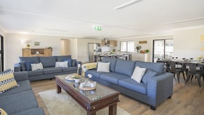 Ett modernt vardagsrum med två soffor, ett soffbord och en matplats med ett bord som är dukat för fyra personer.