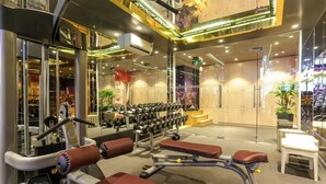 A gym with various exercise equipment, including benches and dumbbells.