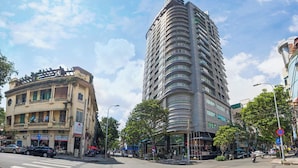 A modern hotel with a curved facade, multiple balconies, and a prominent entrance.