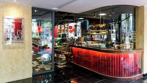 A modern interior with a curved counter, glass doors, and a visible kitchen area.