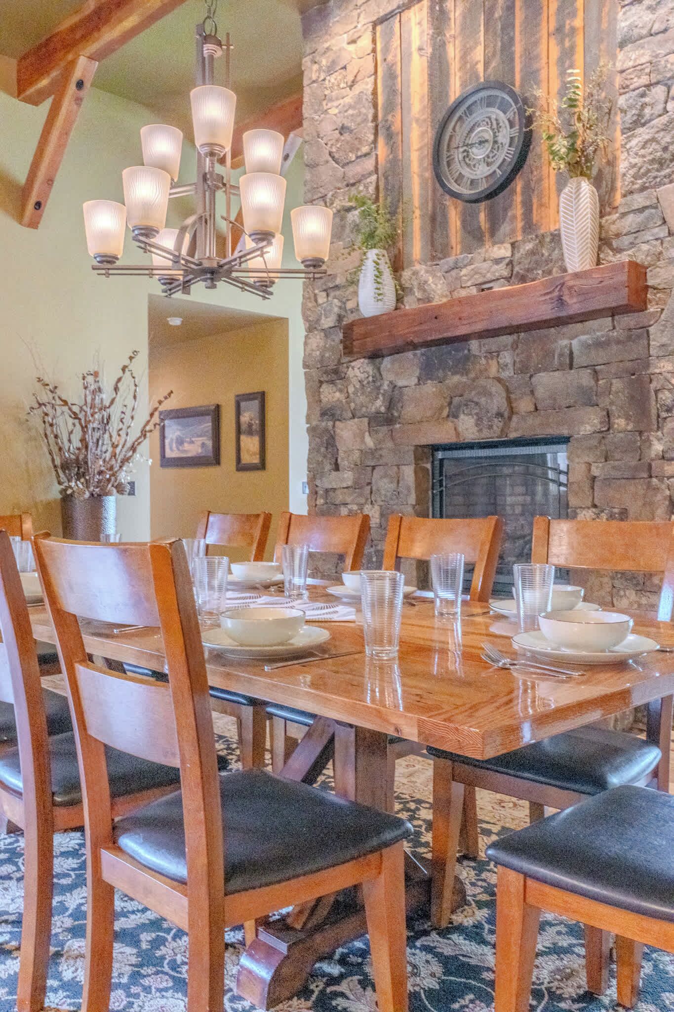 Un comedor con pared de piedra, chimenea y candelabro.