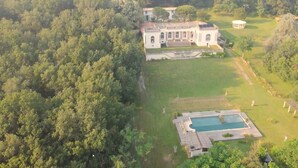 An aerial view of a large estate with a central building, a swimming pool, and extensive greenery. - Chateau de Pourpry (Damiatte)
