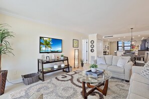 Relax in a stylish living room with a sofa, armchairs, and a TV.