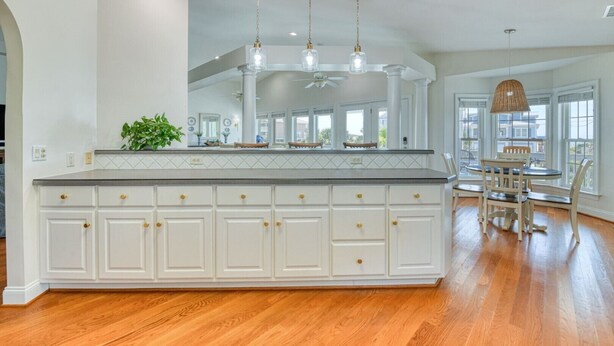 A spacious kitchen with a large island, white cabinetry, and a dining area with a table and chairs. - Lollipops Beach House - Four Bedroom, Three Bath, Private Pool in Long Bay (Myrtle Beach)