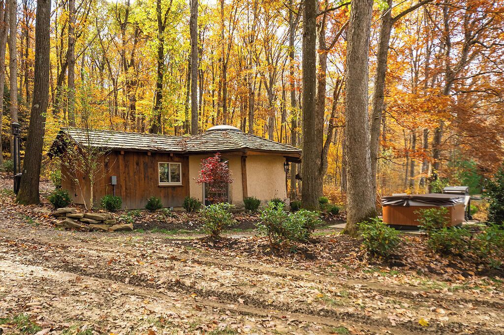A rustic cabin surrounded by autumn trees.