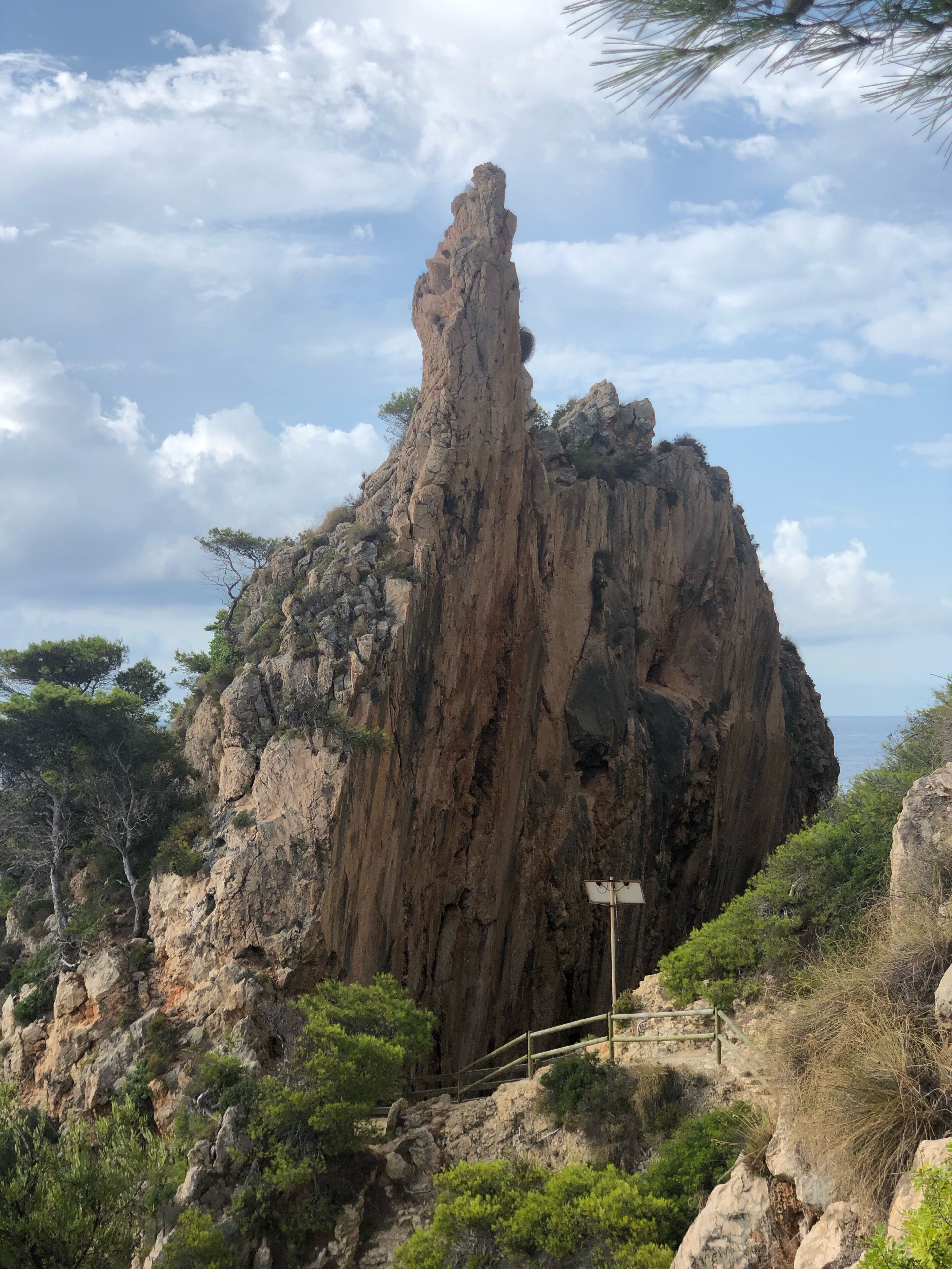 A rocky cliff with a wooden staircase leading up.