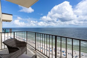A balcony with a view of a beach and ocean.