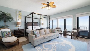 A spacious room with a four-poster bed, a sofa, and a chair, all arranged around a large window offering a view of the ocean. - Phoenix I 1151 by Liquid Life (Orange Beach)
