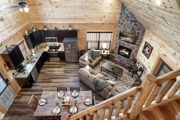 Un intérieur spacieux de chalet en bois, comprenant une cuisine, un coin repas et un salon.