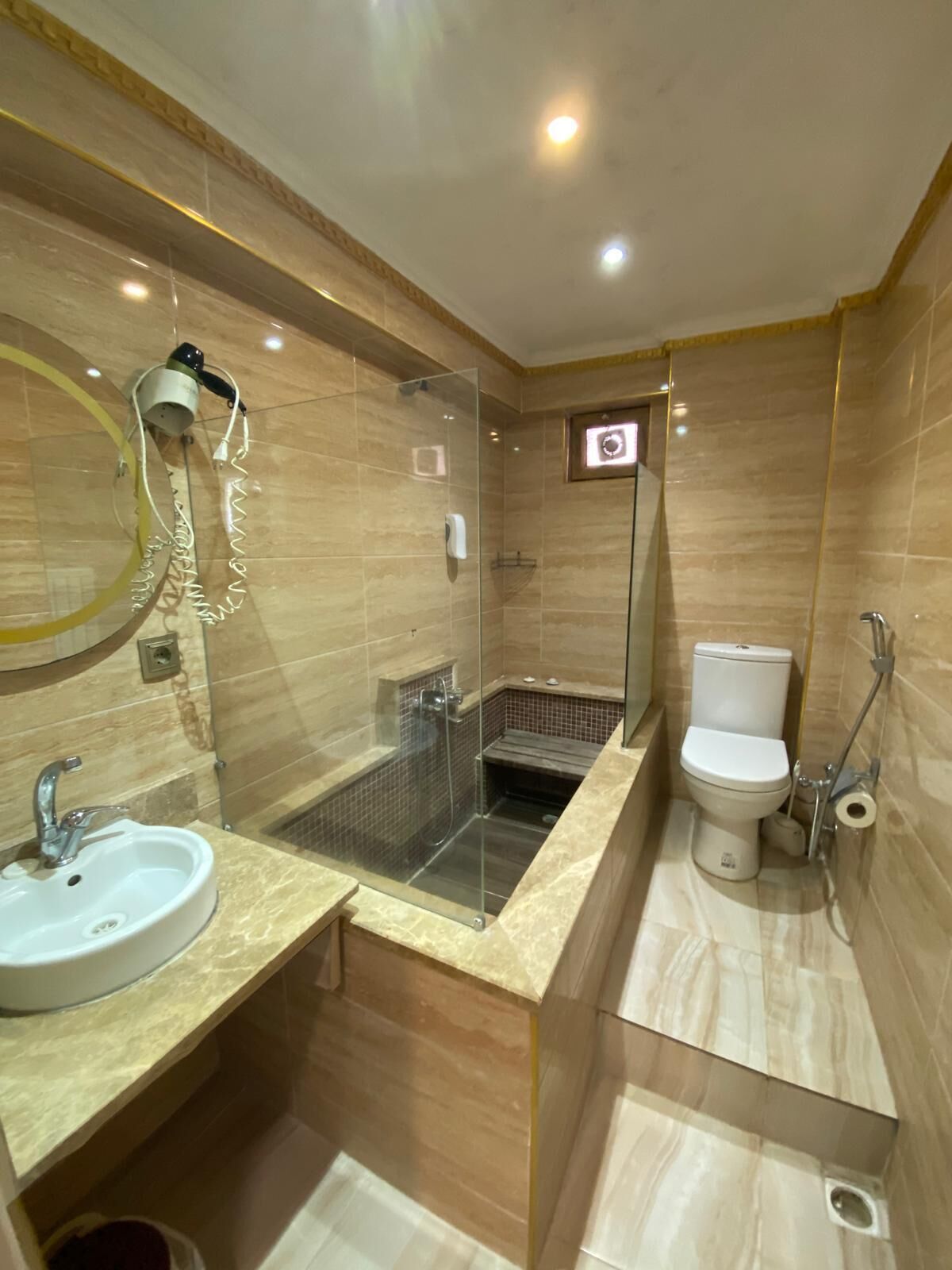 Un baño moderno con ducha de vidrio, inodoro y lavamanos.