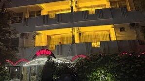 Un edificio de varios pisos con balcones y unidades de aire acondicionado.