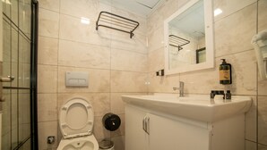 Un baño moderno con inodoro, lavabo y espejo.