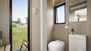 Moderni kylpyhuone, jossa on wc, pesuallas ja ikkuna.