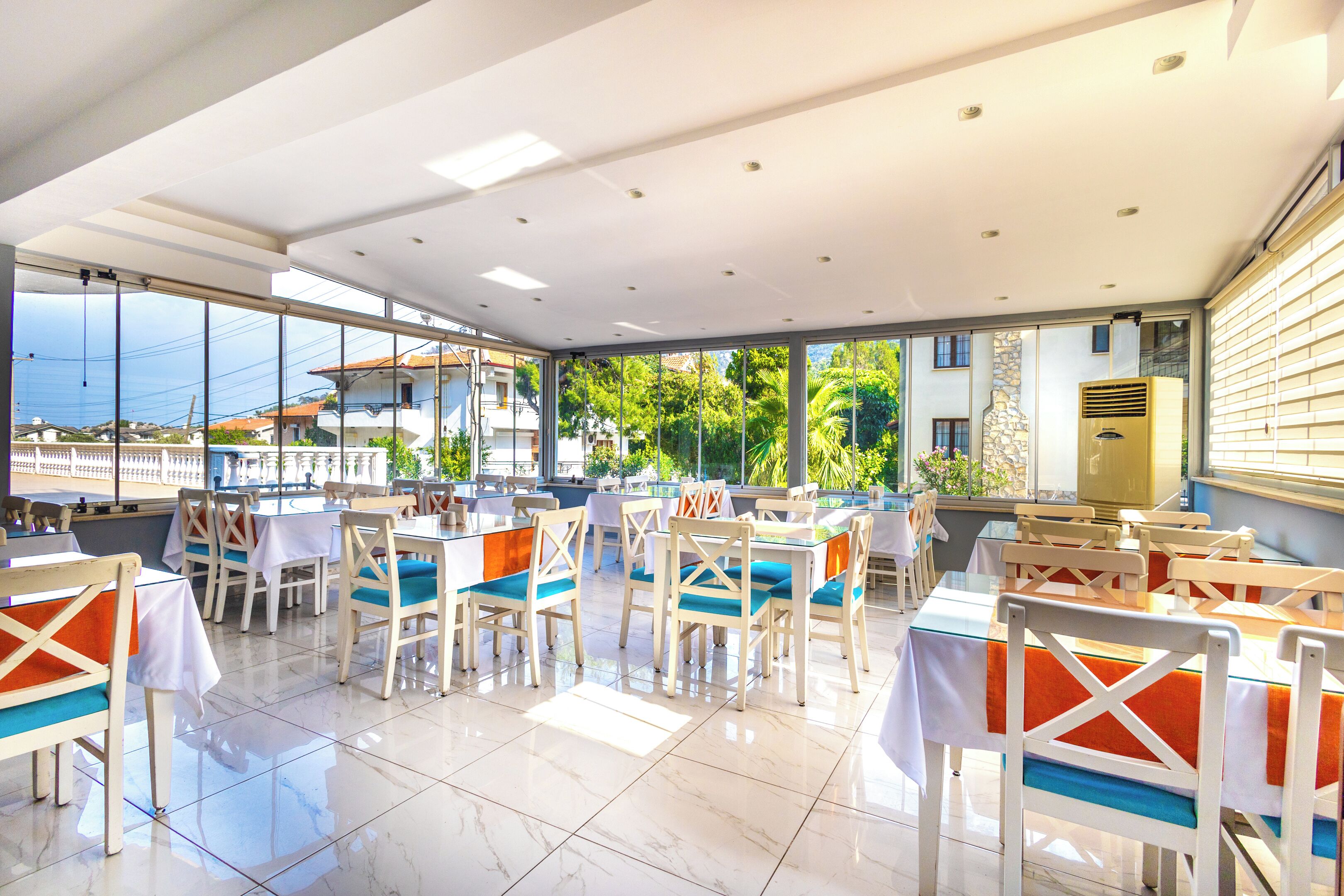 Un restaurante con terraza, grandes ventanales y vistas al mar.