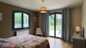 A bedroom with a bed, a chair, a desk, and a window. - At the foot of the mountains: villa des nestes (Saint-Paul)