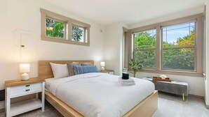 Una camera da letto con un letto grande, due comodini, una panca e due finestre.