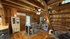 Interior de una cabaña de madera con cocina, comedor y sala de estar.