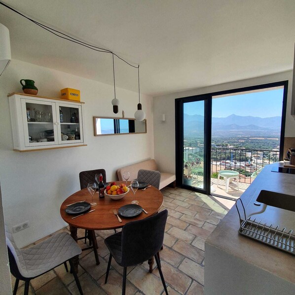 A dining area with a view of a cityscape and mountains.
