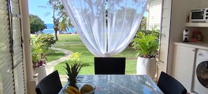 Enjoy a romantic meal for two in this secluded outdoor dining area with a table set amidst lush greenery and ocean views.