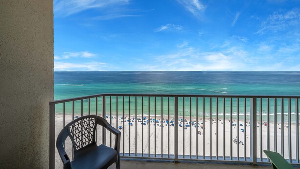Un balcon avec vue sur une plage et l’océan.
