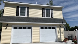 A two-story house with a garage, a number 618, and a small patio with potted plants.
