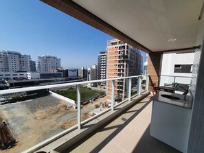Enjoy breathtaking city views from this spacious balcony with a sink and glass railing.