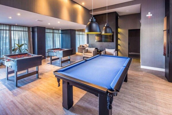 Relax and have fun in this spacious room with a pool table and foosball tables, perfect for socializing and entertainment.