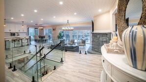 Een ruime woonkamer met een hoge plafond, een open haard en een grote spiegel.