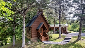 A log cabin with a porch and steps leading to the entrance, surrounded by trees. - Cozy Mountain Retreat w/hot tub, 5 mins to downtown strip (Sevierville)