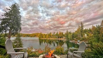 Une vue sur le lac, avec deux fauteuils Adirondack placés face à un feu de camp.