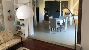 A dining area with a white table and chairs, a hanging light fixture, and a bookshelf with books. - 5 minutes from the national park Holiday home for hikers, cyclists, anglers (Lunow-Stolzenhagen)