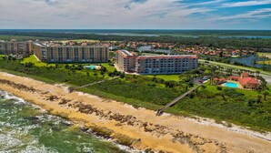 Un resort costero con varios edificios altos, una playa y un lago.