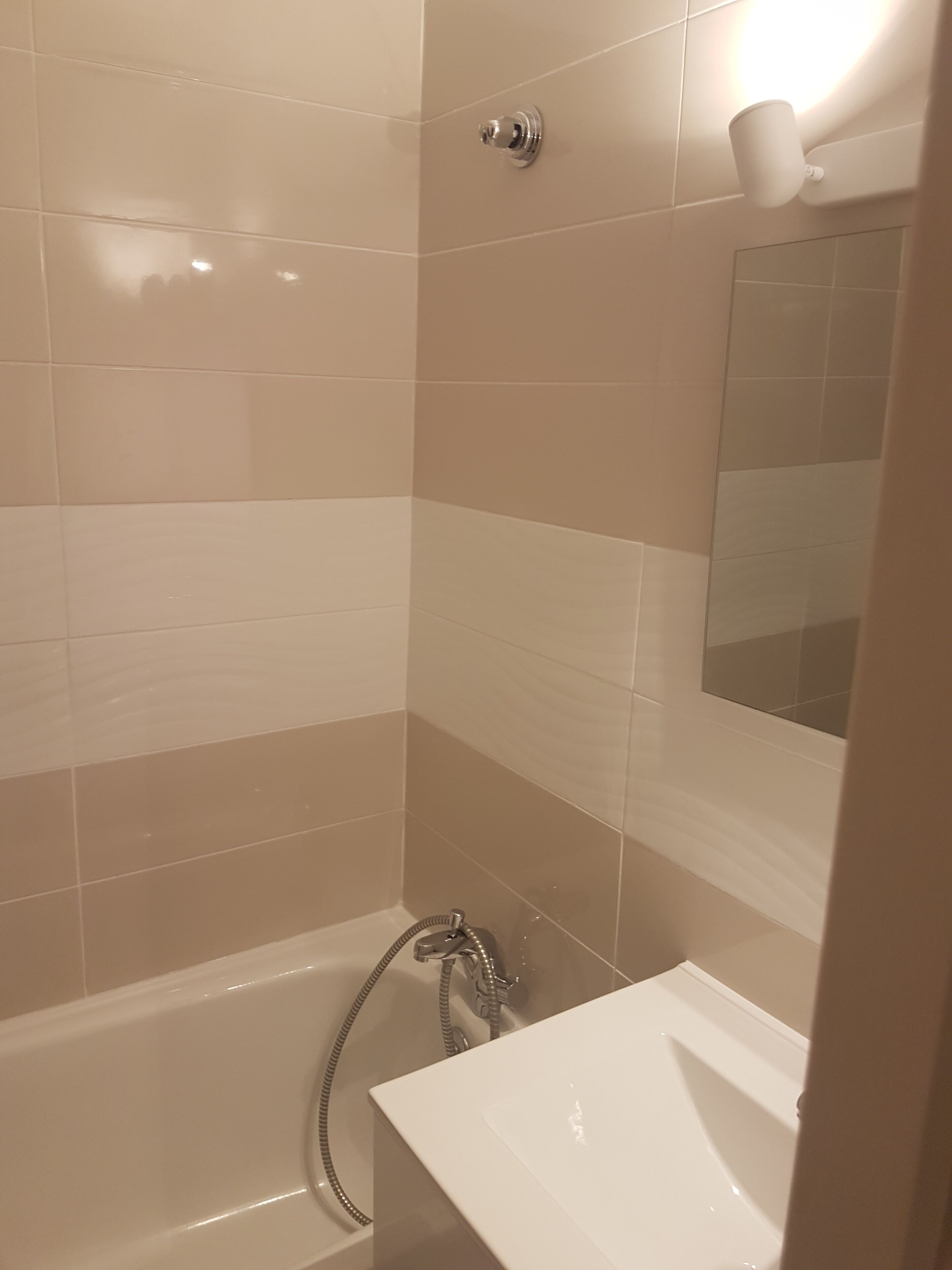 A bathroom with a bathtub, a shower, and a sink.