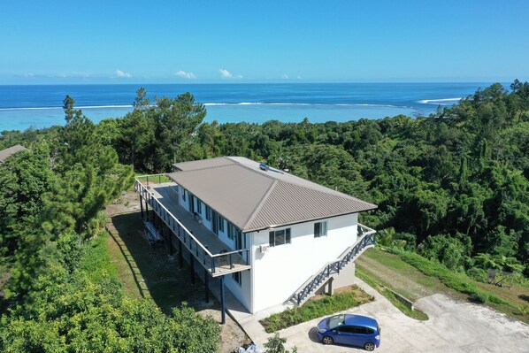 A two-story house with a balcony overlooking a beach, surrounded by dense greenery. - Belle Balise (Korolevu)