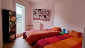 A bedroom with two beds, a radiator, and a poster on the wall. - Grand F3, Avec Balcon Plein sud Sans vis à vis (Vannes)
