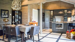 A modern kitchen with dark cabinets, a central island, and a chandelier. - Lovely home in Vossestrand with WiFi (Vossestrand)
